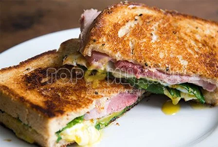 Жареный сэндвич с зеленью, яйцом, сыром и ветчиной